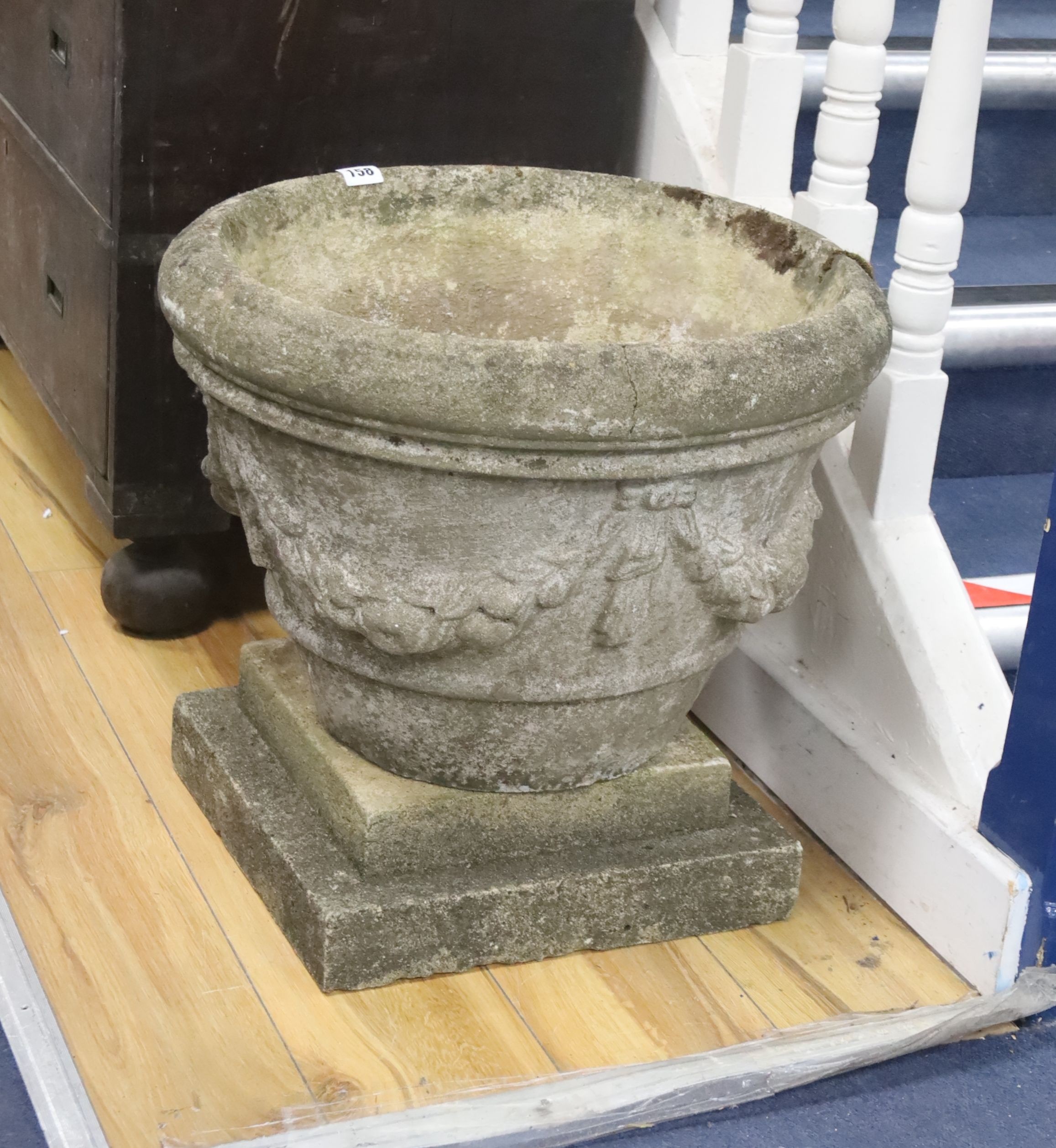 A circular reconstituted stone garden planter on square plinth, diameter 49cm, height 46cm